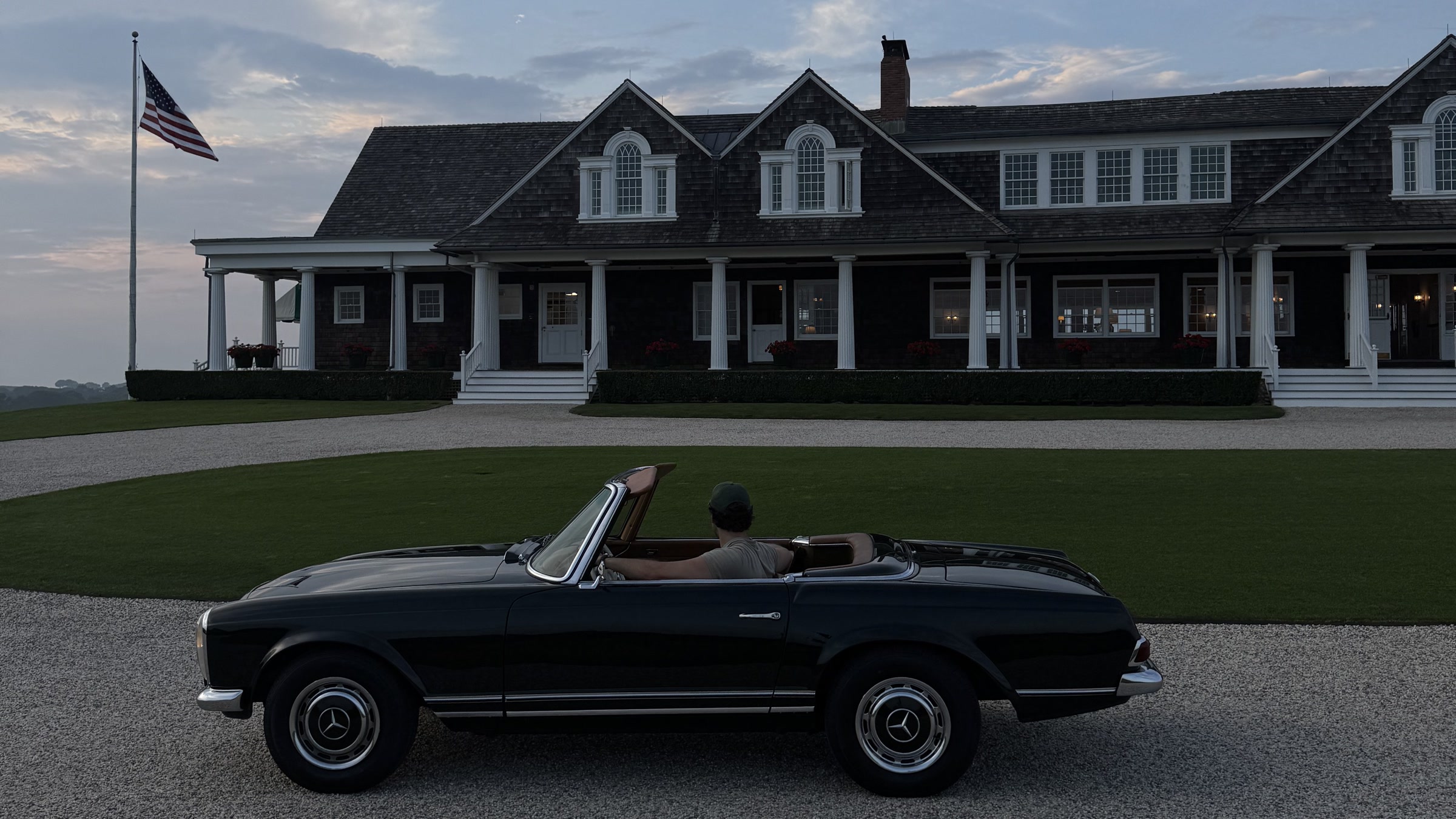 Dark Mercedes-Benz Pagoda outside a coastal home